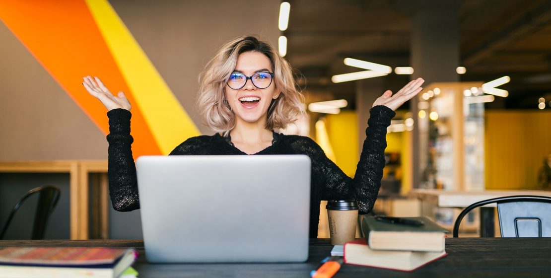 Mujer sonrientes tras una computadora